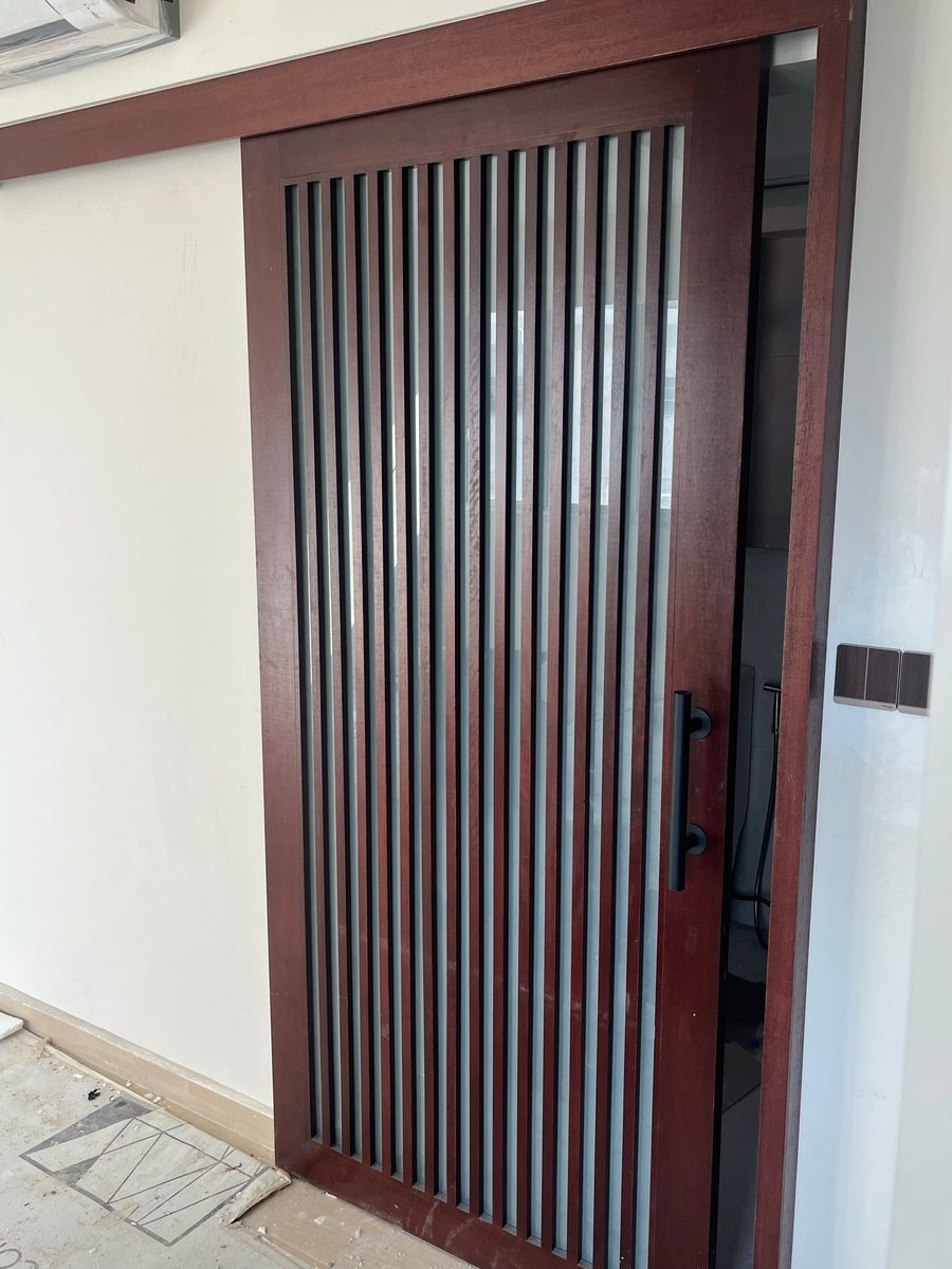 Fluted red-timber sliding door, installed by Door Empire Singapore