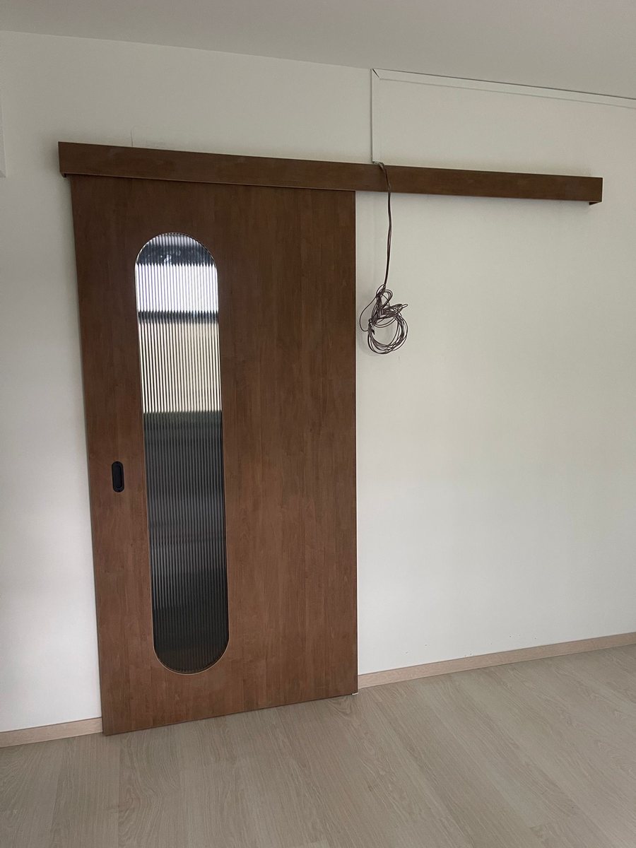 Walnut sliding door with oval glass, installed by Door Empire Singapore